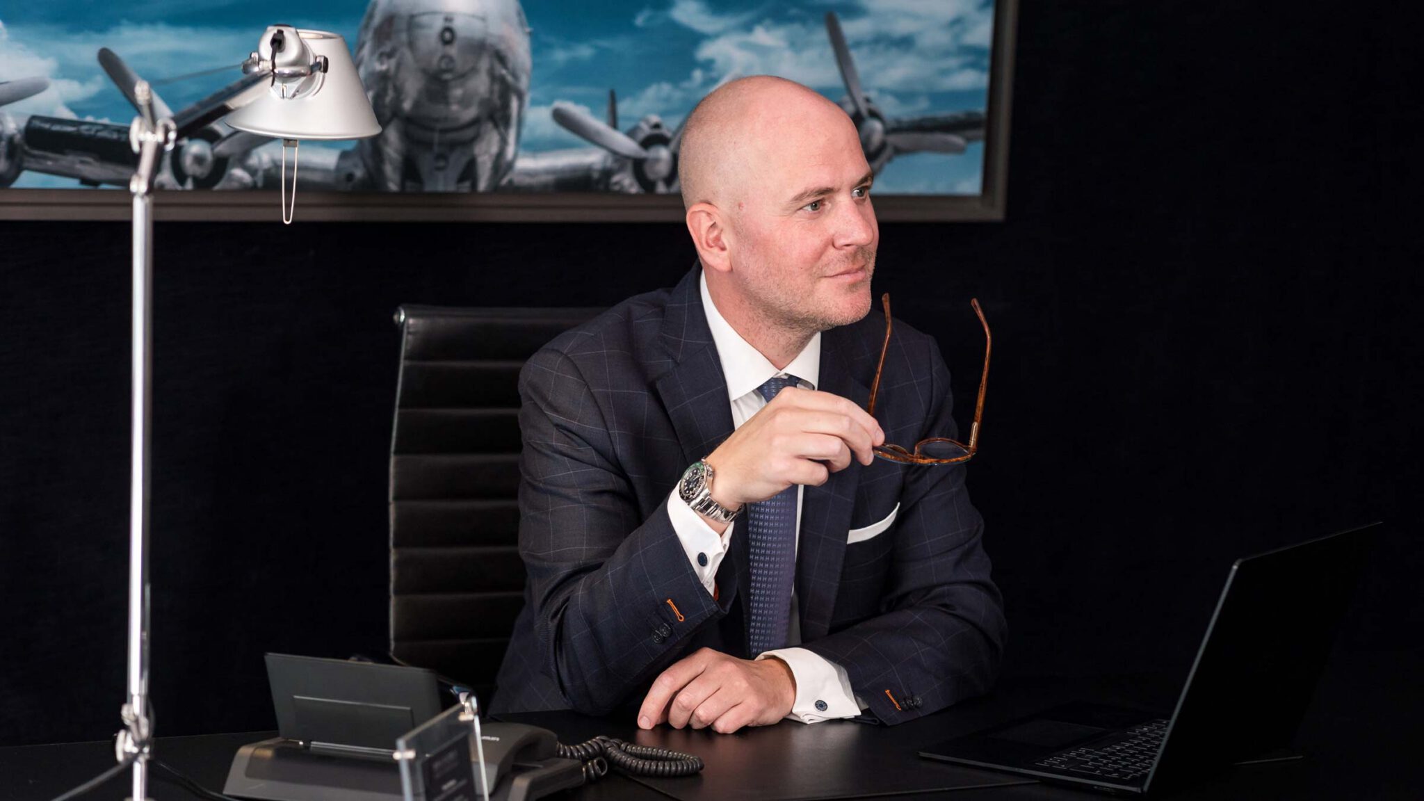 Fachanwalt für Strafrecht Martin Bücher von Birkenstock Rechtsanwälte sitzt lächelnd an seinem Schreibtisch und berät Mandanten.